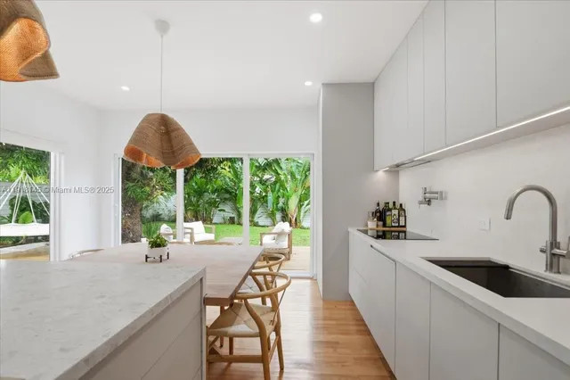a kitchen with stainless steel appliances a table a sink and cabinets