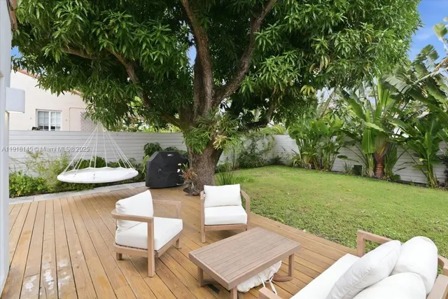 a balcony with wooden floor table and chairs