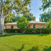 a front view of a house with a yard and trees
