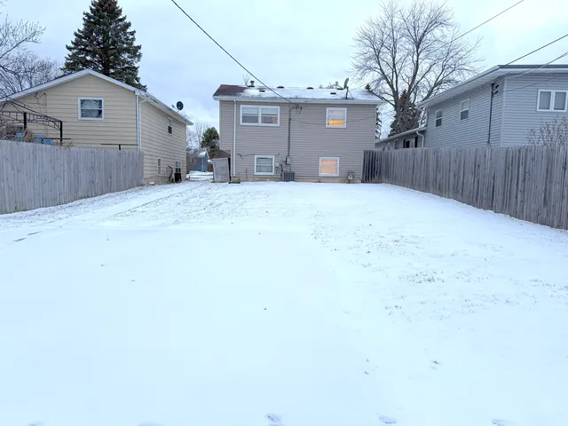 a view of a house with a yard and wooden fence
