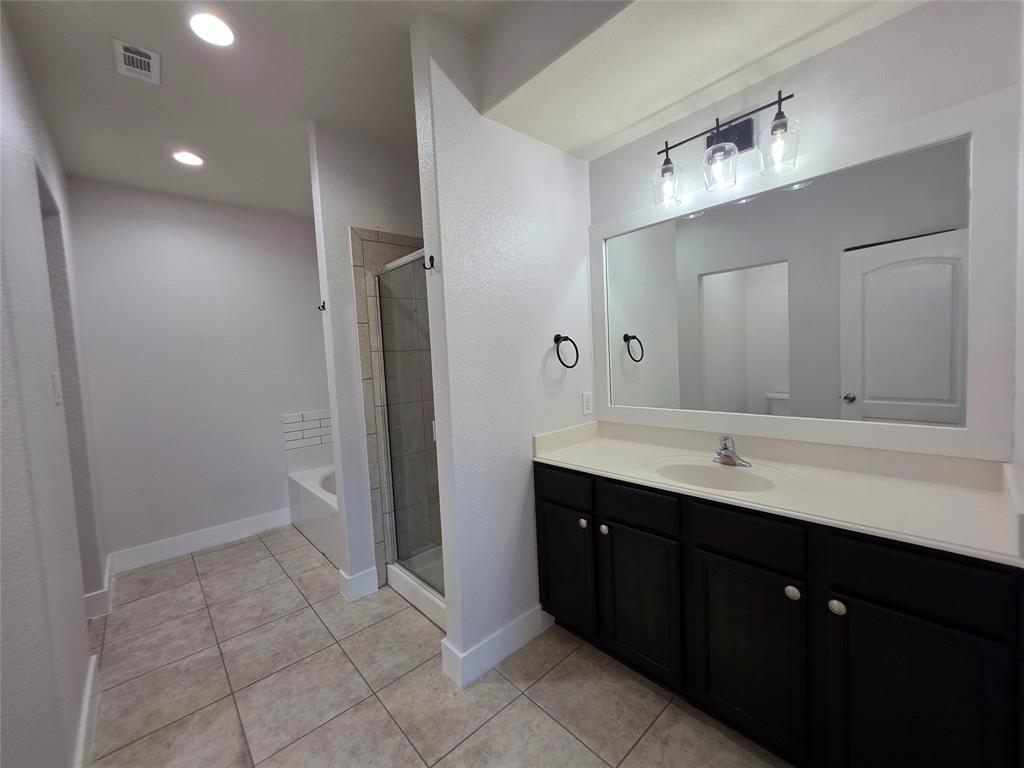 149 Ryan Street Anna, TX 75409 - Photo 17 of 38 a bathroom with a double vanity sink a mirror and a toilet