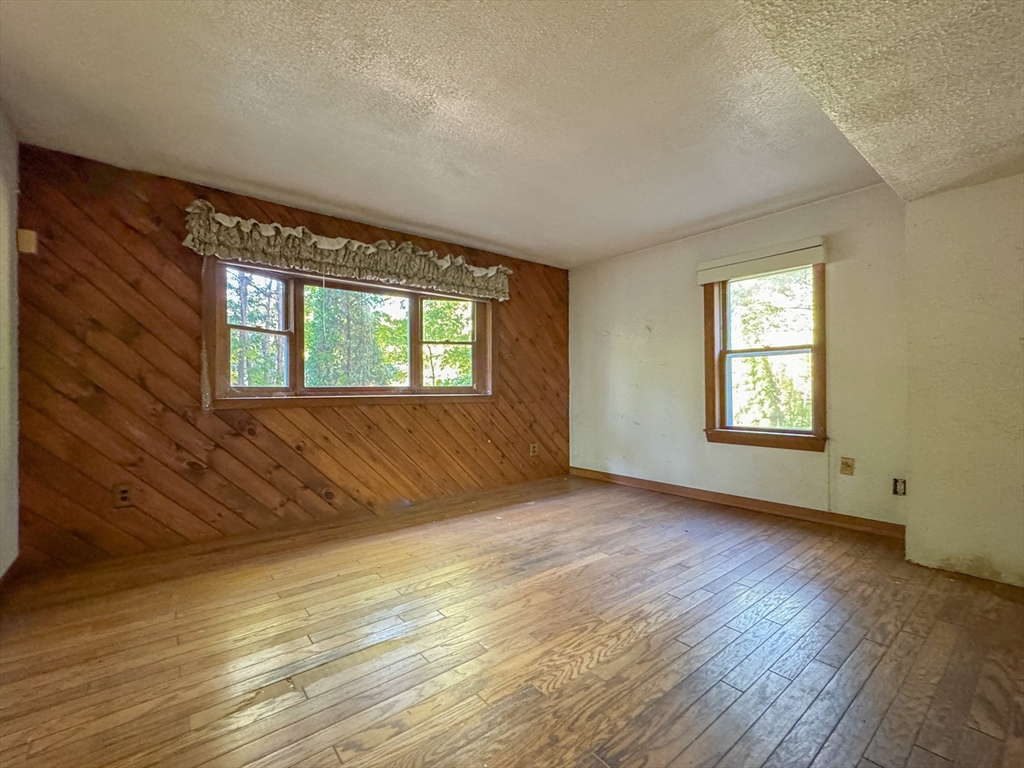 132 Kilbourn Road Lancaster, MA 01523 - Photo 11 of 15 a view of an empty room with wooden floor and a window