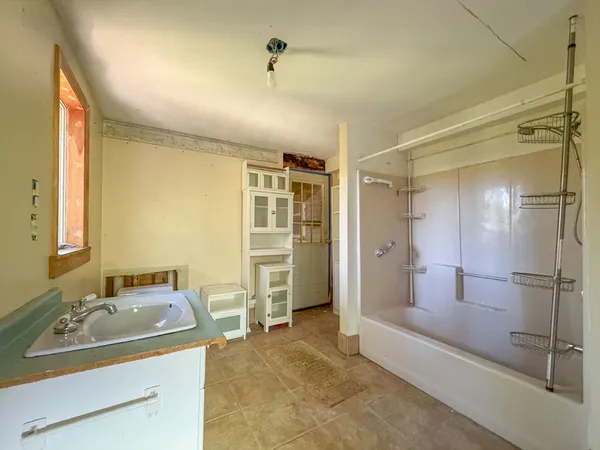 a bathroom with a sink shower and a mirror