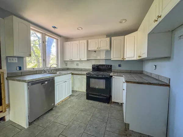 a kitchen with a stove sink and cabinets