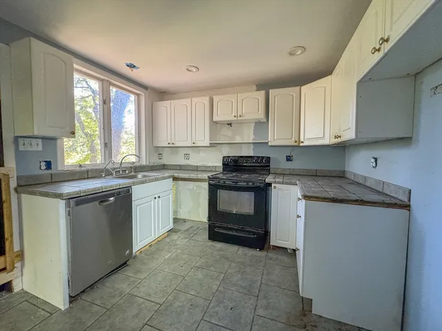 a kitchen with a stove sink and cabinets