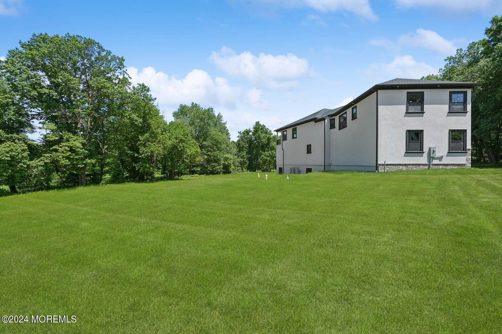 16 Round Hill Holmdel, NJ 07733 - Photo 50 of 60 a backyard of a house with potted plants and large tree
