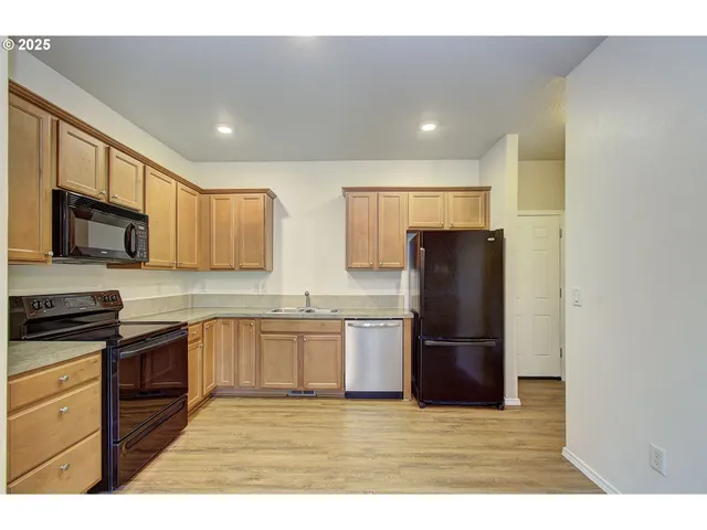 a kitchen with granite countertop stainless steel appliances and refrigerator