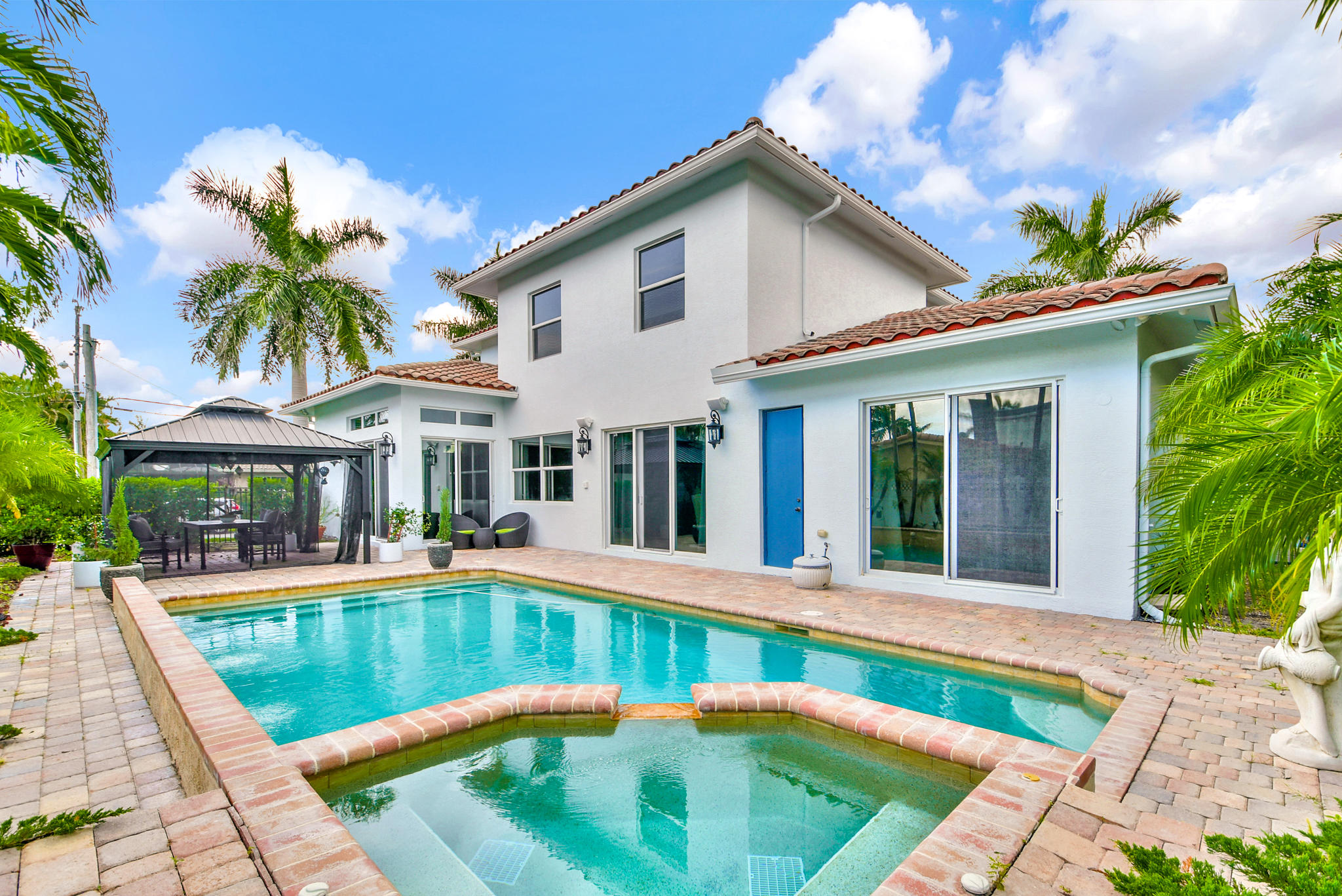 7100 Northeast 7th Avenue Boca Raton, FL 33487 - Photo 3 of 35 a view of a white house with a swimming pool and a yard