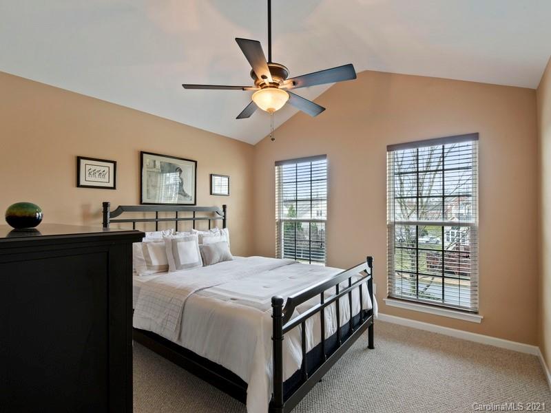 7726 Wiltshire Ridge Road Charlotte, NC 28269 - Photo 18 of 26 a bedroom with a bed and a chandelier