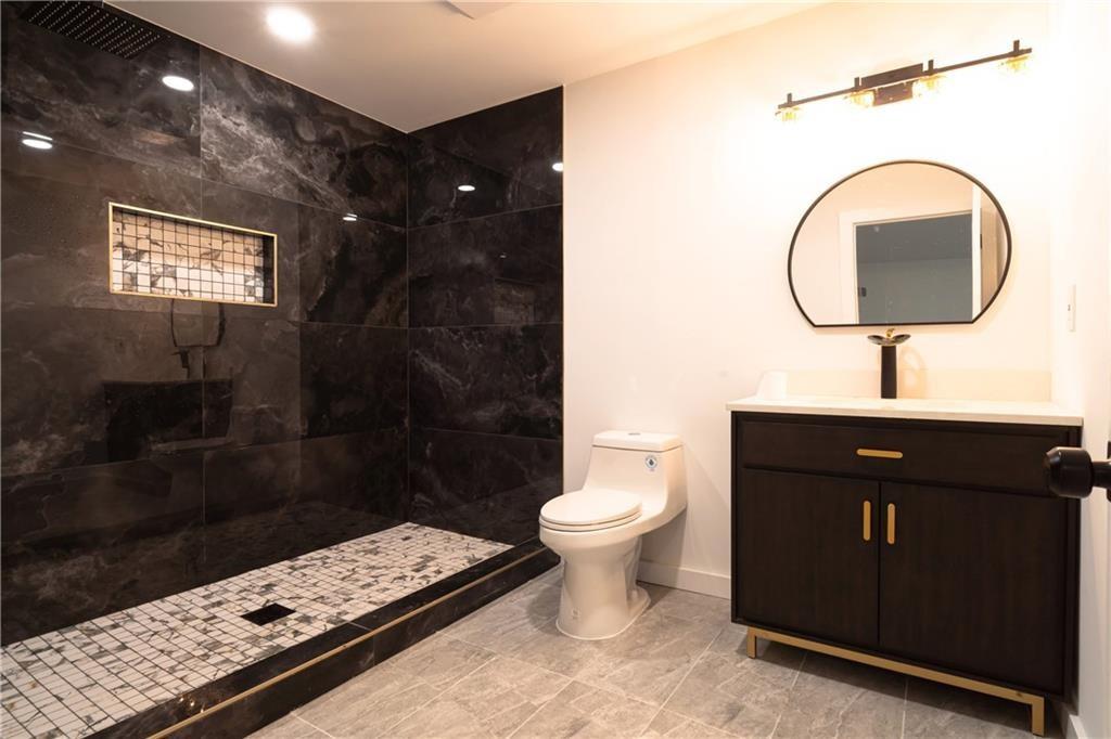 69 Hearn Road Ellenwood, GA 30294 - Photo 19 of 19 a bathroom with a toilet sink vanity granite and mirror