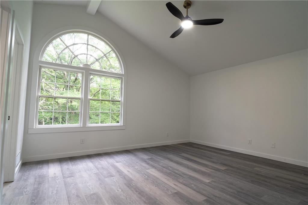 69 Hearn Road Ellenwood, GA 30294 - Photo 4 of 19 an empty room with wooden floor fan and windows