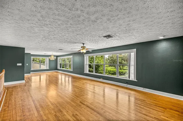 a kitchen with a dining table chairs wooden floor and appliances