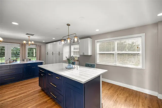 a view of a hallway with wooden floor and a bathroom