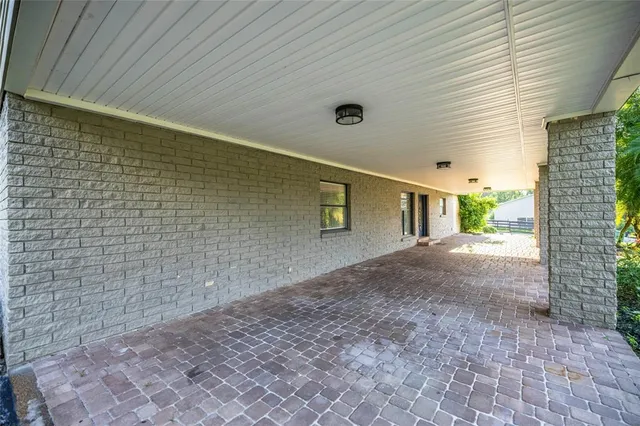 a view of an empty room with wooden floor ceiling fan and a window