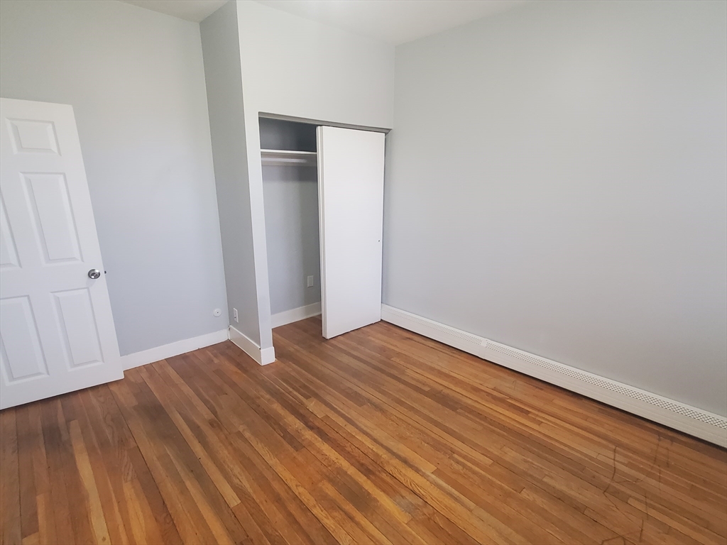 10 Abbotsford Street, Unit 9 Boston, MA 02121 - Photo 11 of 14 a view of an empty room with wooden floor