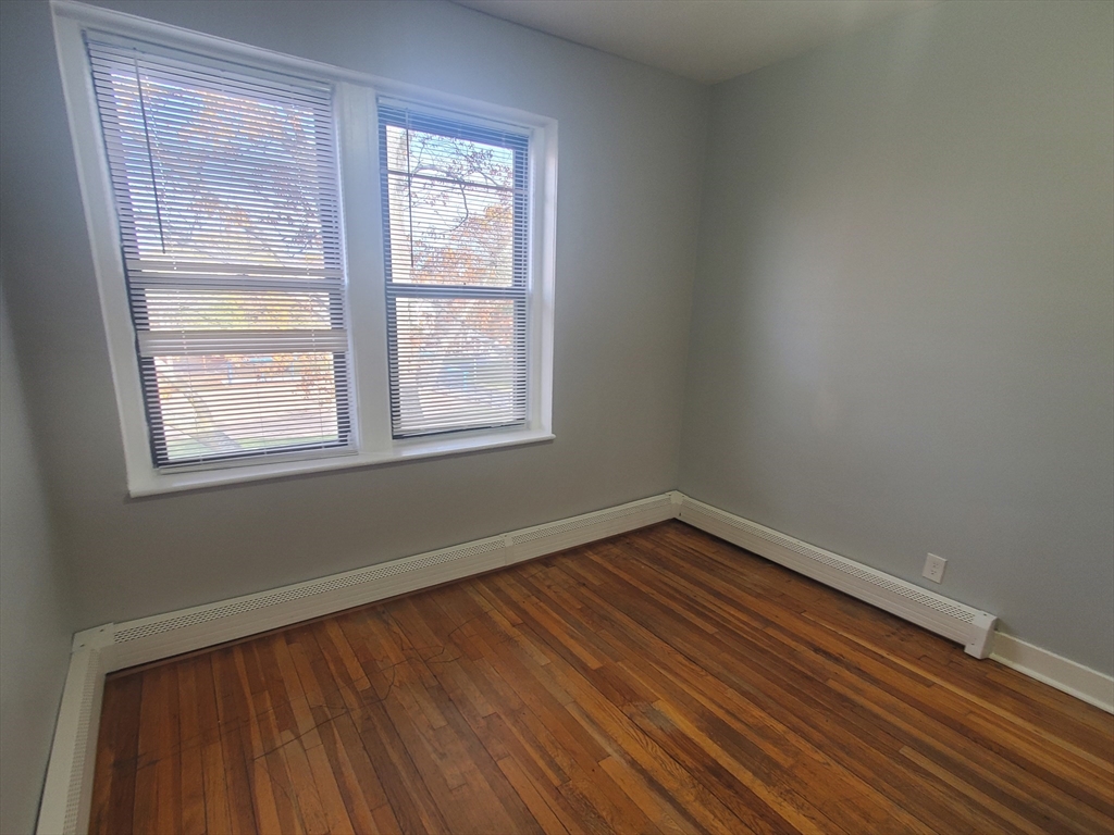 10 Abbotsford Street, Unit 9 Boston, MA 02121 - Photo 12 of 14 an empty room with wooden floor and windows