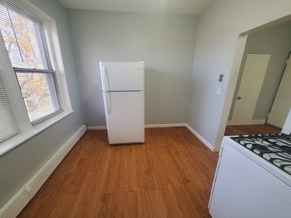 10 Abbotsford Street, Unit 9 Boston, MA 02121 - Photo 2 of 14 a kitchen with wooden floors and white appliances