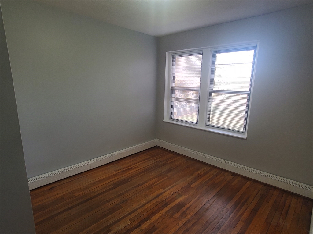 10 Abbotsford Street, Unit 9 Boston, MA 02121 - Photo 10 of 14 an empty room with wooden floor and windows