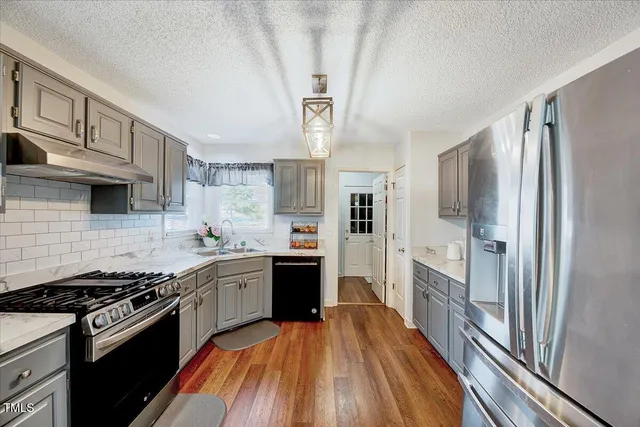 a kitchen with stainless steel appliances a stove sink and refrigerator