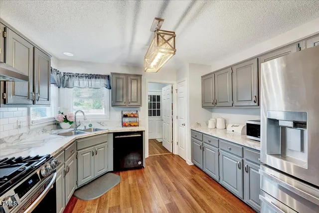 a kitchen with stainless steel appliances granite countertop a sink stove and refrigerator