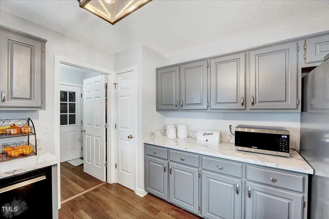 a kitchen with stainless steel appliances a stove refrigerator and cabinets