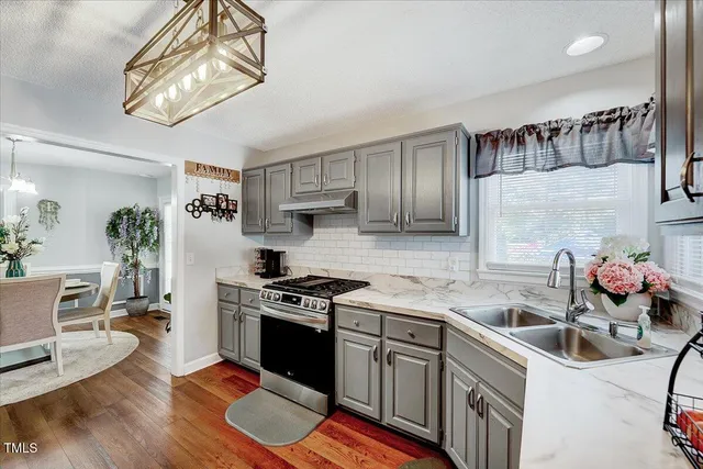 a kitchen with stainless steel appliances granite countertop a sink dishwasher stove and cabinets