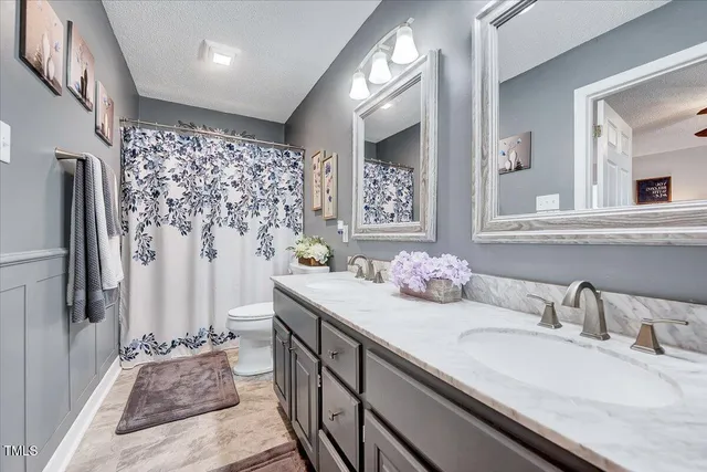 a bathroom with double vanity sinks a shower and a mirror