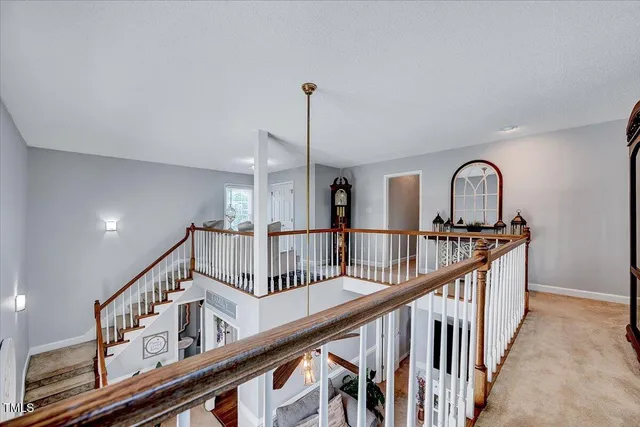 a view of staircase with railing and white walls