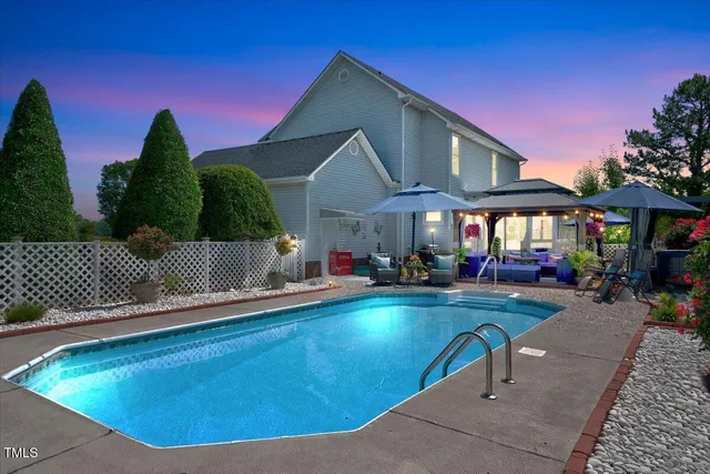 a view of a house with swimming pool and sitting area