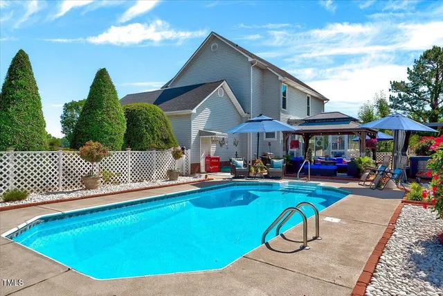 a view of a house with swimming pool and sitting area