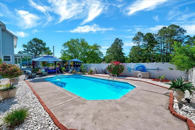an outdoor space with swimming pool and furniture