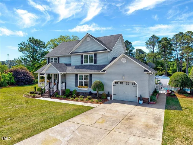 a view of house with garden and tall tress