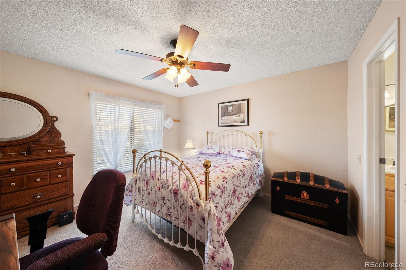 3657 South Laredo Street, Unit A Aurora, CO 80013 - Photo 17 of 26 a bedroom with a bed and a chandelier