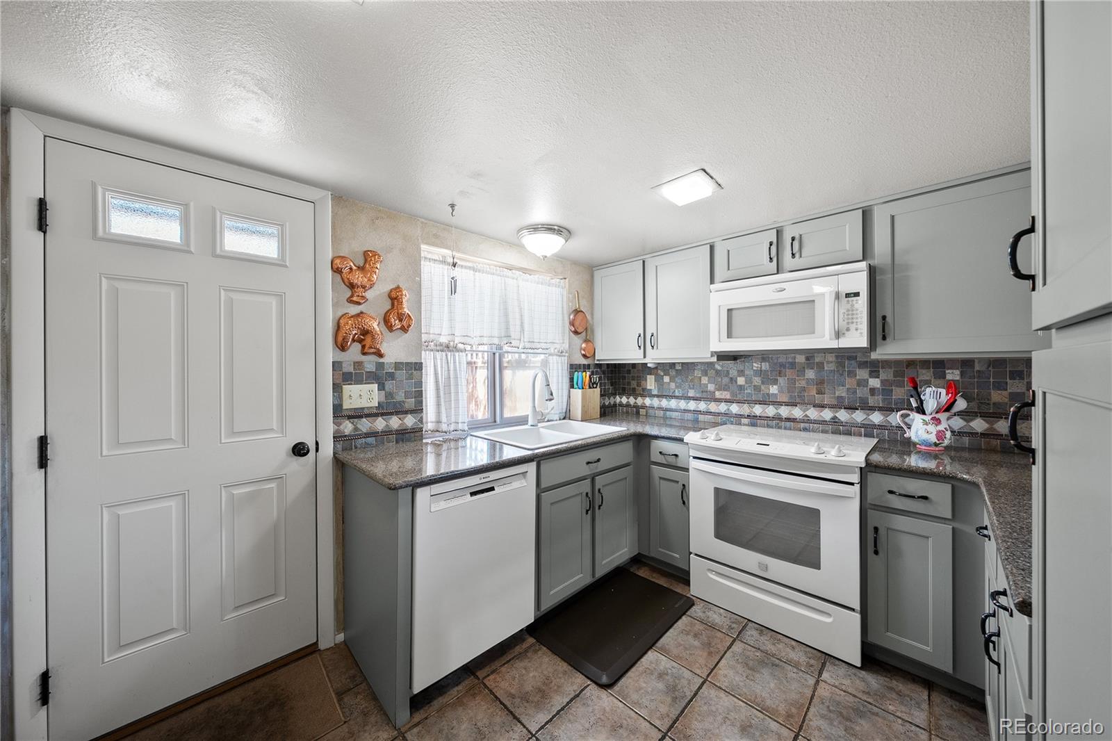 3657 South Laredo Street, Unit A Aurora, CO 80013 - Photo 10 of 26 a kitchen with stainless steel appliances granite countertop a sink and cabinets