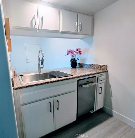 a kitchen with granite countertop a sink and cabinets