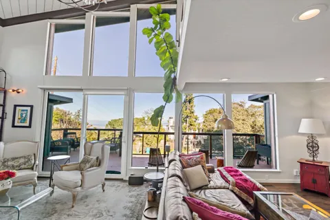 a balcony view with chairs and potted plants