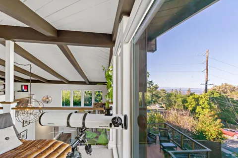 a dining room with furniture a chandelier and kitchen view