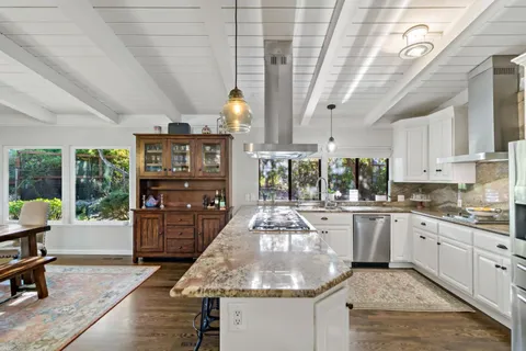 a bathroom with a granite countertop tub sink and mirror