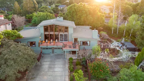 a living room with furniture a flat screen tv and a floor to ceiling window
