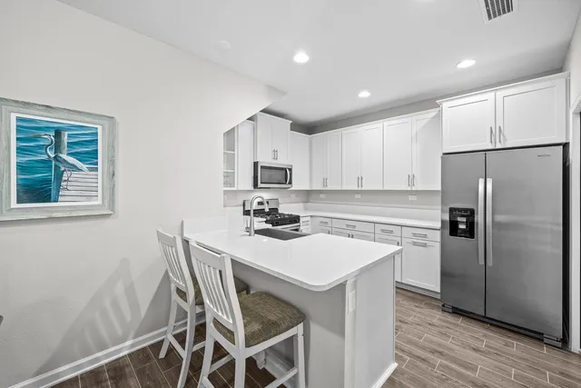 a kitchen with stainless steel appliances a refrigerator sink and microwave