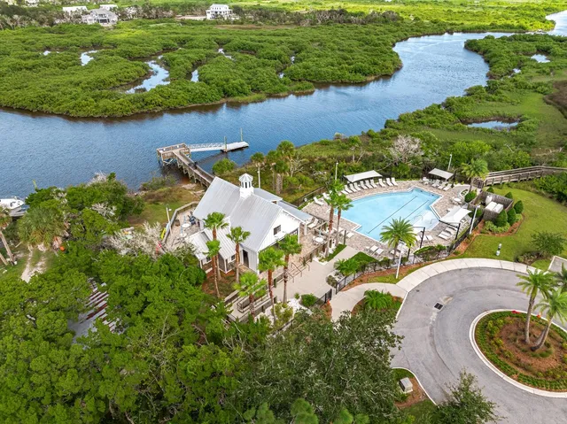 a view of a swimming pool with lawn chairs under an umbrella