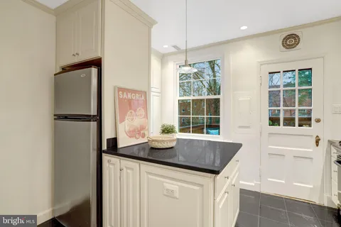 a kitchen with granite countertop a sink and a refrigerator