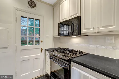 a kitchen with granite countertop a stove and a cabinet