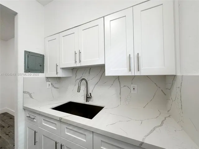 a kitchen with stainless steel appliances granite countertop white cabinets sink and dishwasher