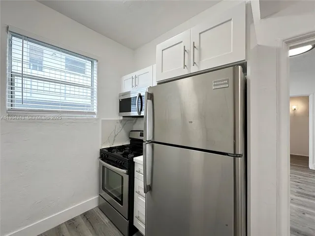 a white refrigerator freezer and a stove sitting inside of a kitchen
