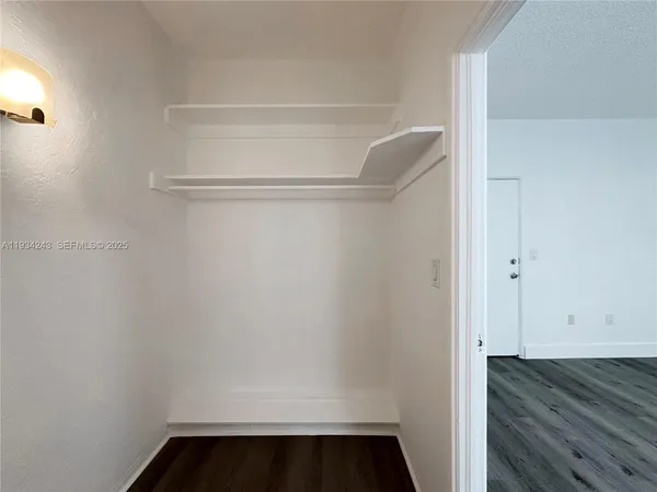 a view of walk in closet with wooden floor