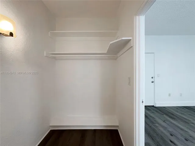 a view of walk in closet with wooden floor