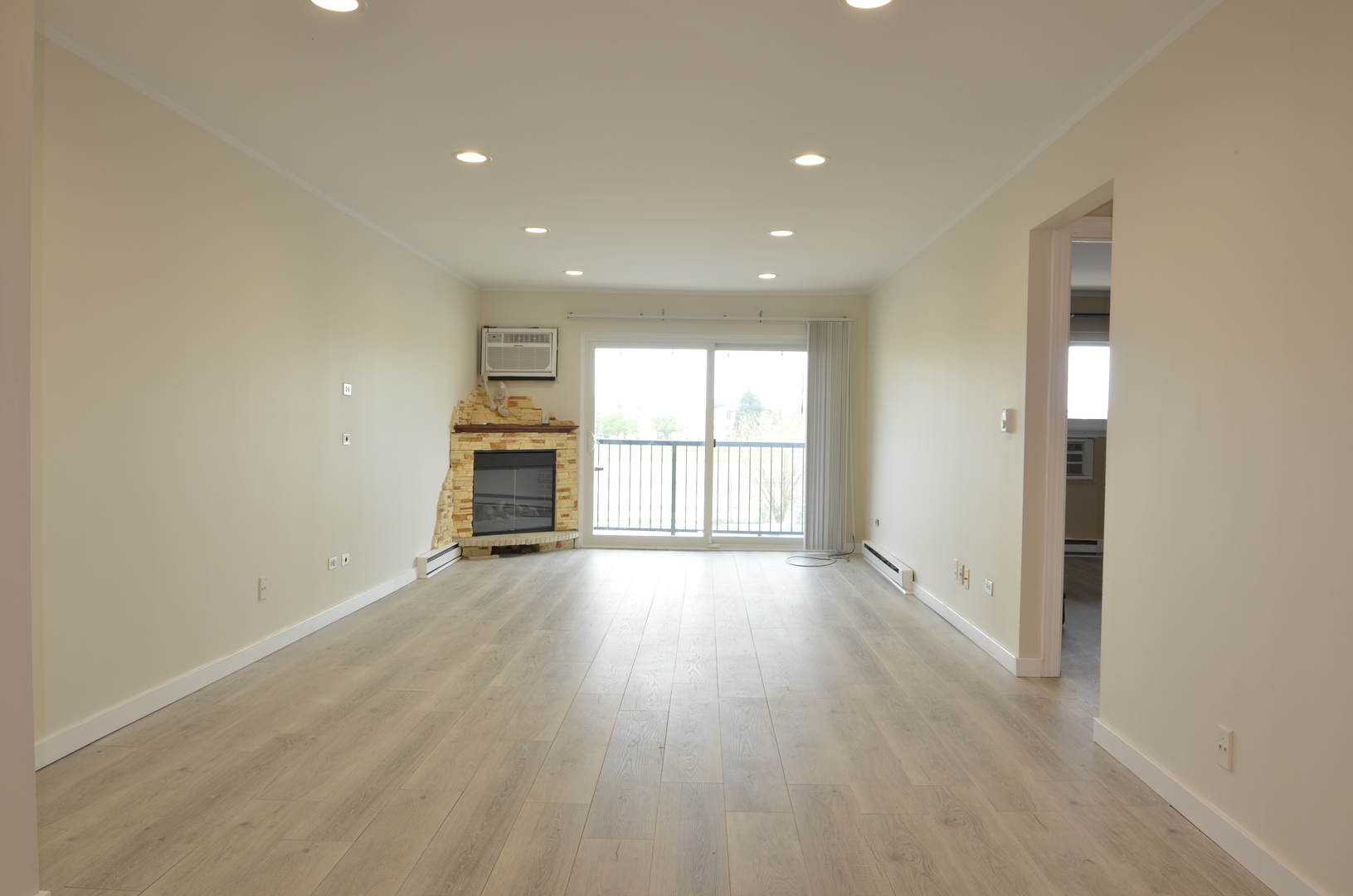 826 East Old Willow Road, Unit 206 Prospect Heights, IL 60070 - Photo 3 of 15 an empty room with wooden floor fireplace and windows