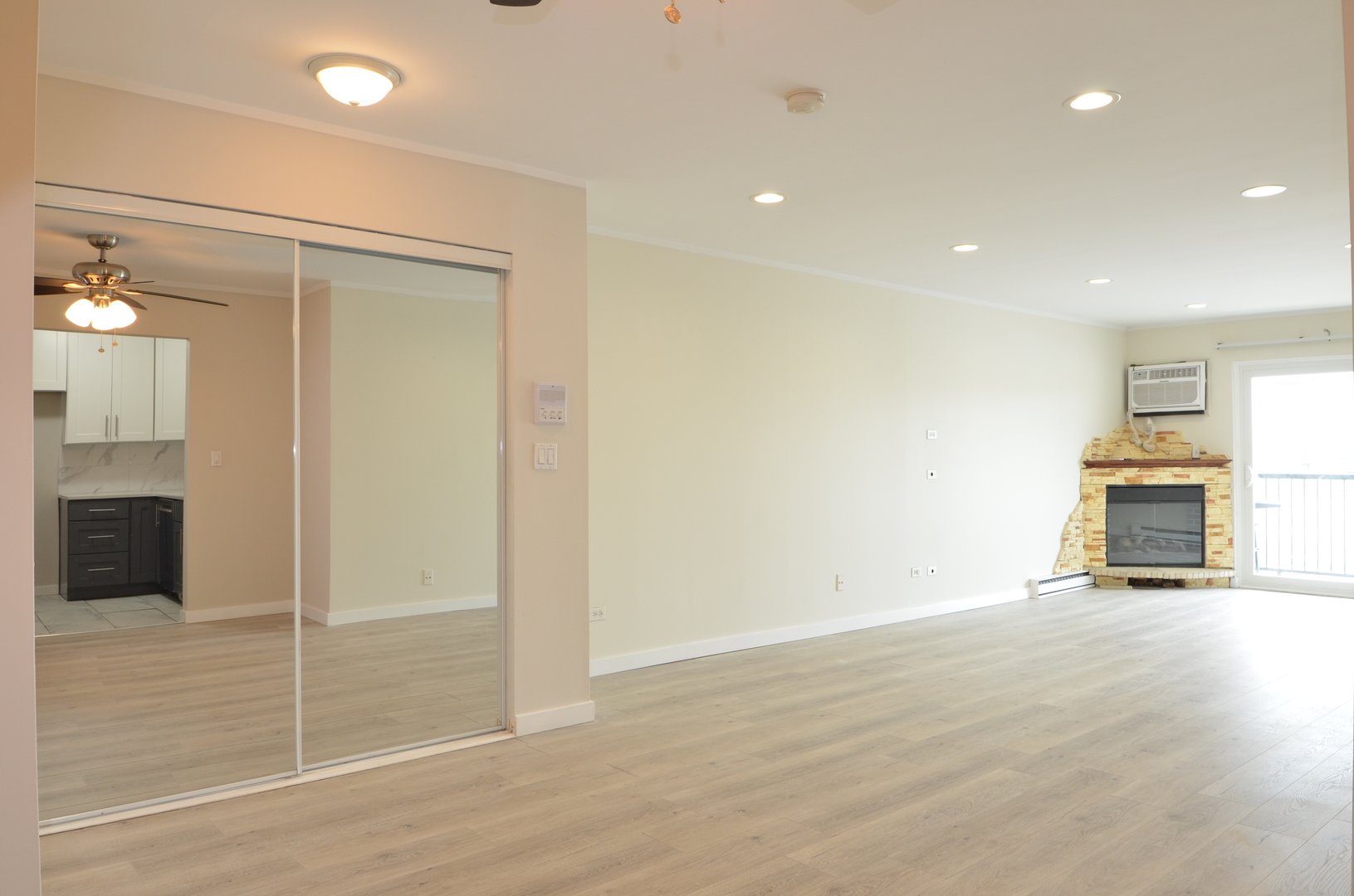 826 East Old Willow Road, Unit 206 Prospect Heights, IL 60070 - Photo 6 of 15 an empty room with wooden floor and way to kitchen