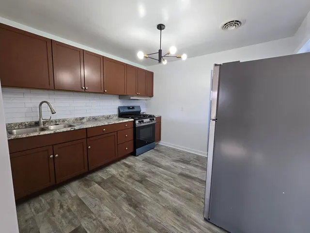 a kitchen with stainless steel appliances granite countertop cabinets and refrigerator